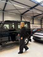 Model walking through a car showroom with the Buchan small cargo bag in black