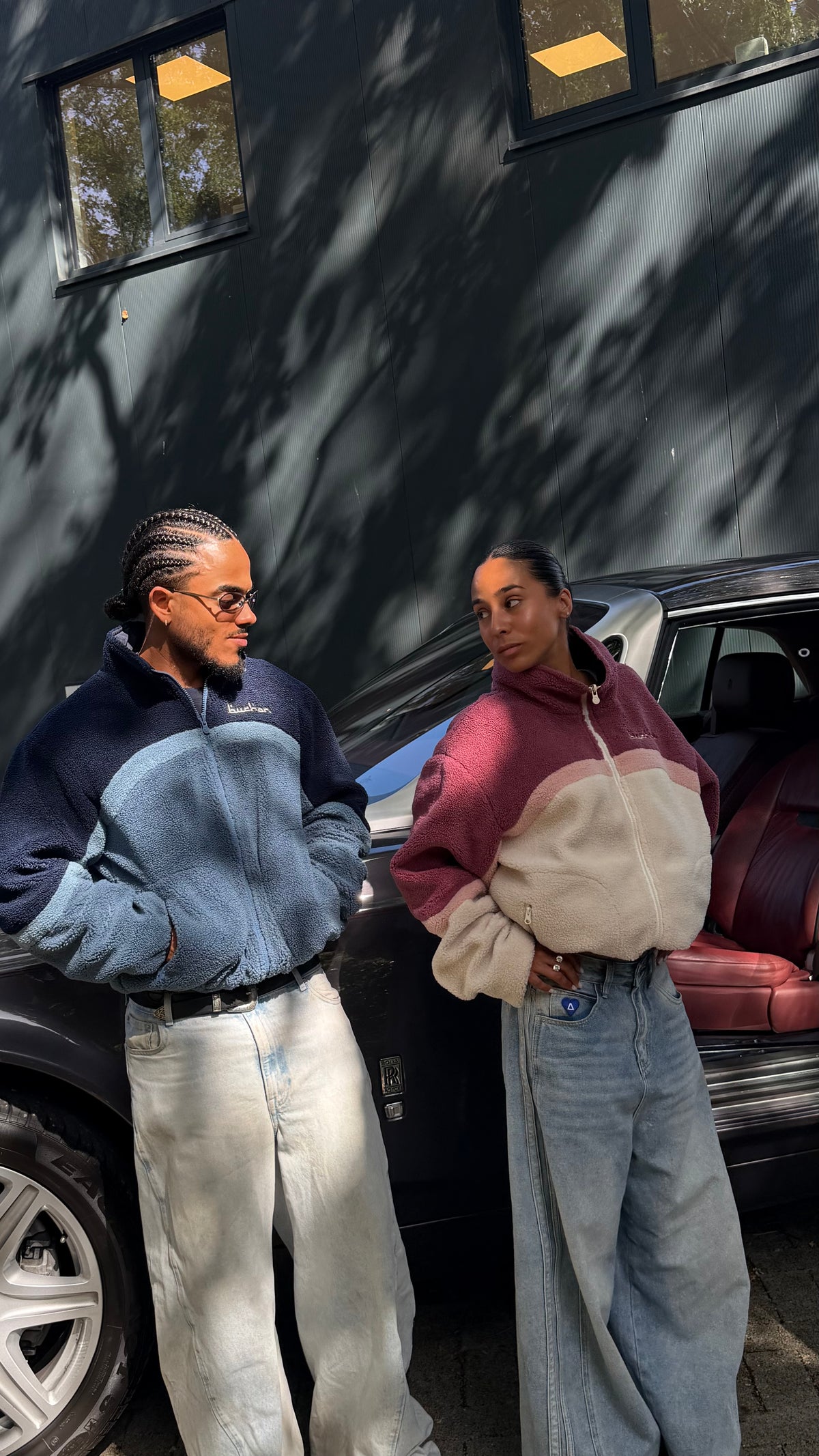 Two models by a car, one in the reversible Buchan fleece in blue with navy and light blue sherpa